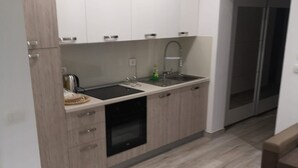 A modern kitchen with white cabinets, a double sink, and a built-in oven. - Apartman Sea Lake Magic 2 (Vinodol)