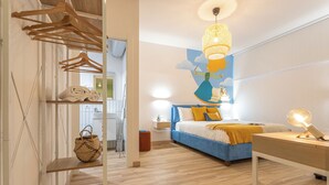 Une chambre à coucher moderne avec un lit, une table de chevet et un luminaire suspendu.