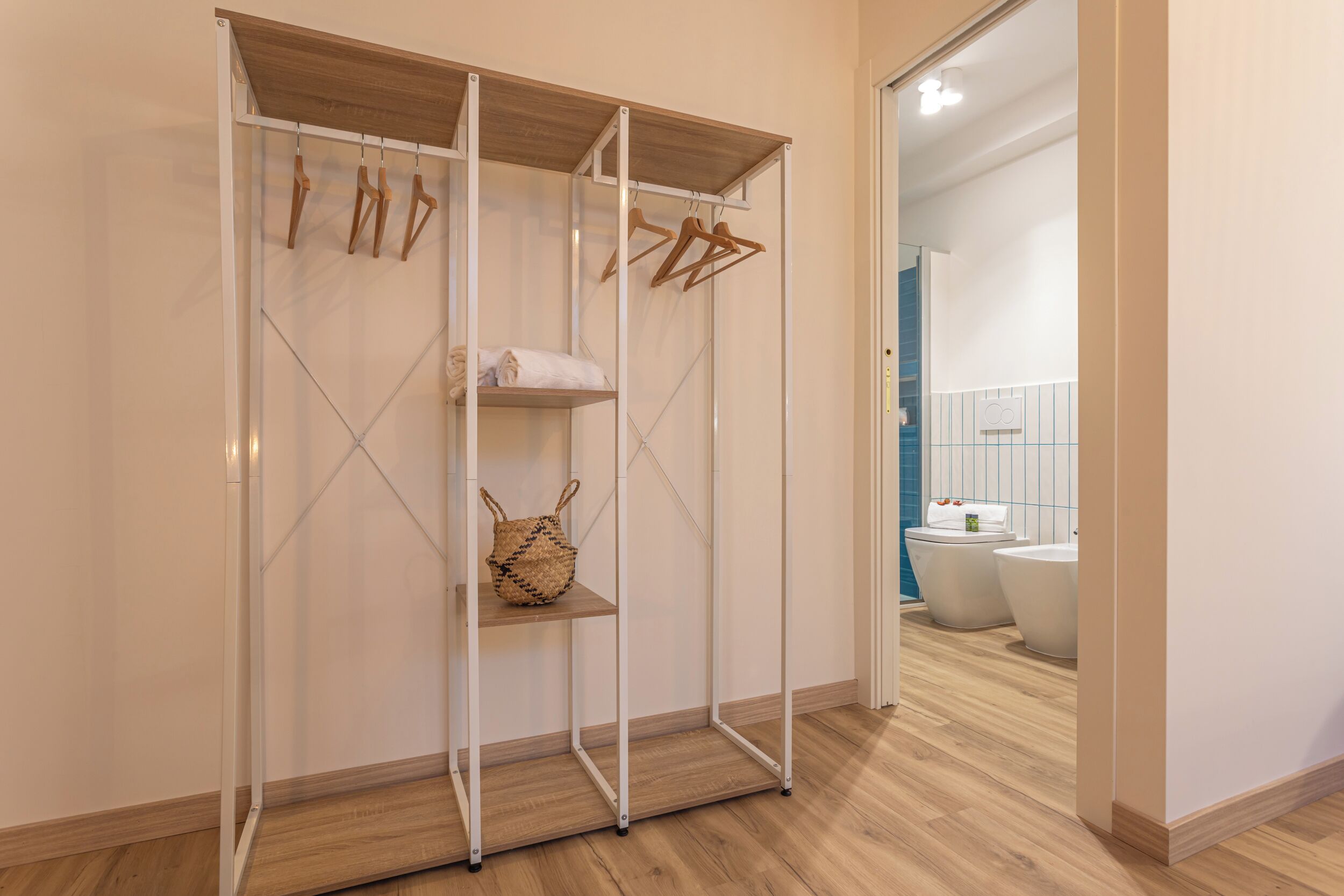 Un dressing avec des étagères en bois, une tringle à vêtements et un panier.