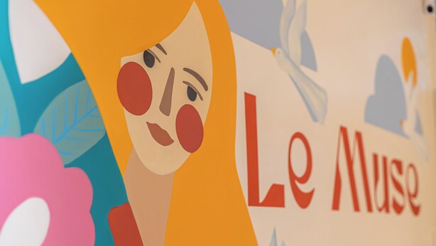 Une fresque colorée, ornée de formes abstraites et du texte « Le Muse ».