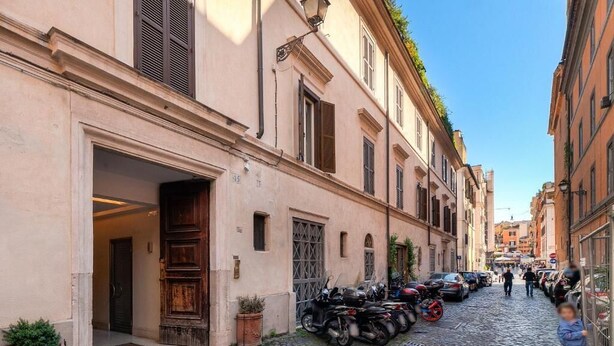 A narrow cobblestone street lined with historic buildings, parked motorcycles, and a few cars. - Colosseum Sweet Life Apartment  (Rome)