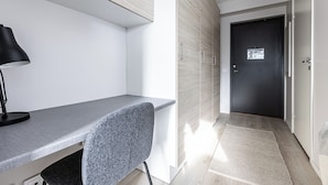 Un espacio de oficina moderno con un escritorio, una silla y una computadora.