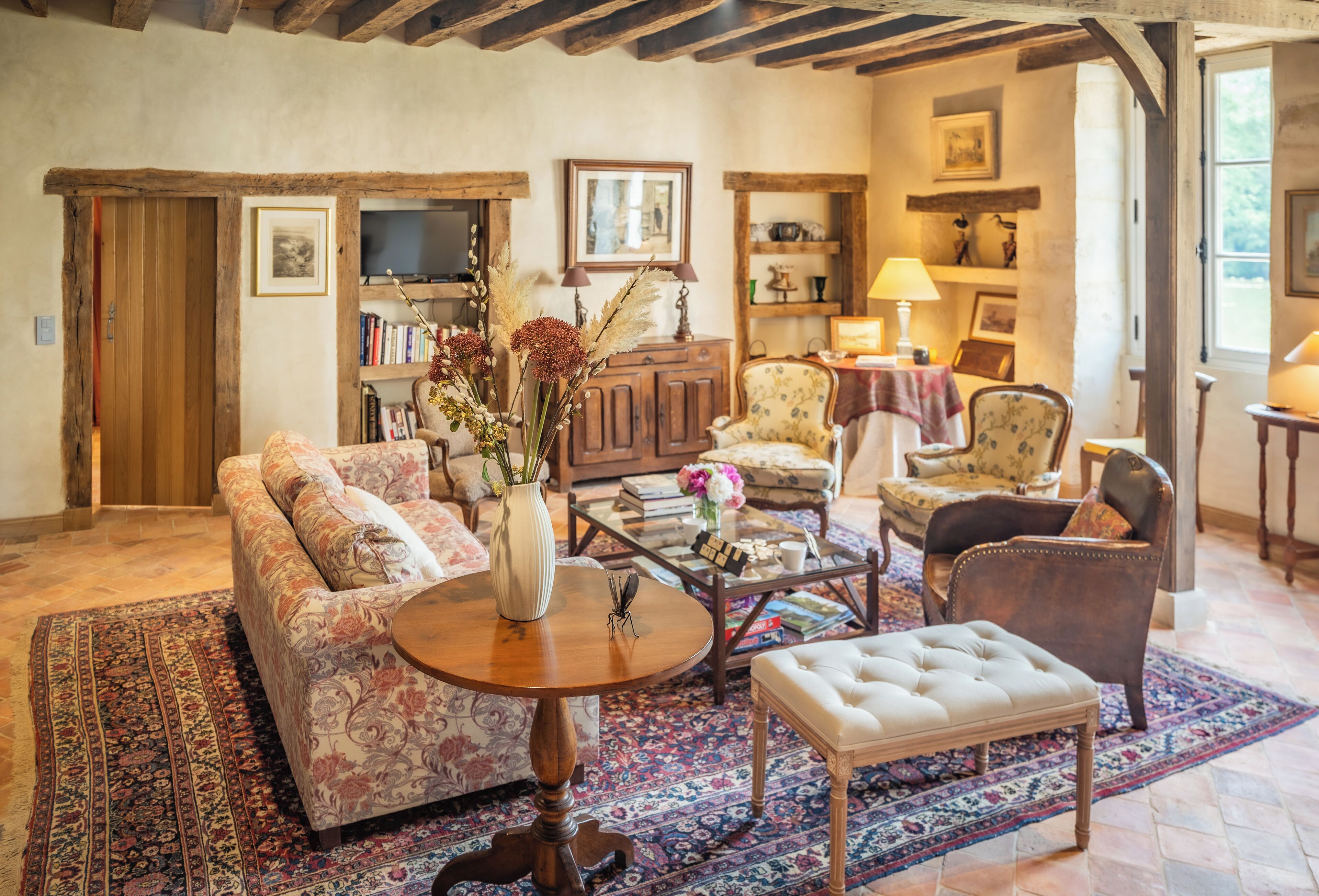A cozy living room with a sofa, armchairs, a coffee table, and a rug.