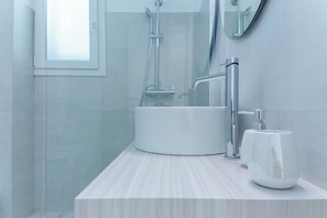 A modern bathroom with a white sink, a mirror, and a shower. - B&B SOLE (Ugento)