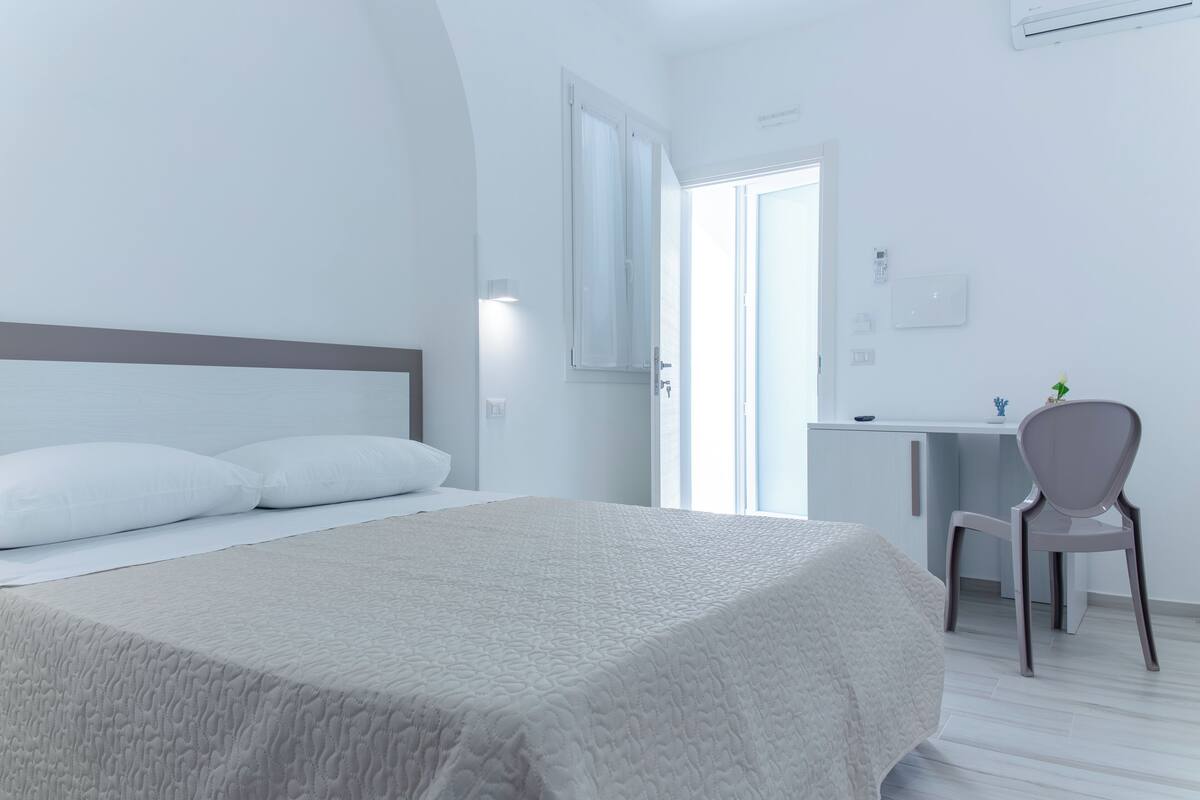 Un dormitorio con una cama, un escritorio y una silla.