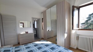 Une chambre à coucher comprenant un lit, une commode, un miroir et un dressing.