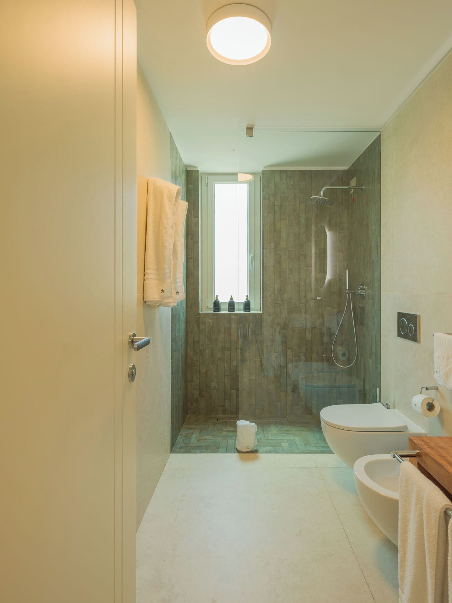 A bathroom with a shower, toilet, and sink.