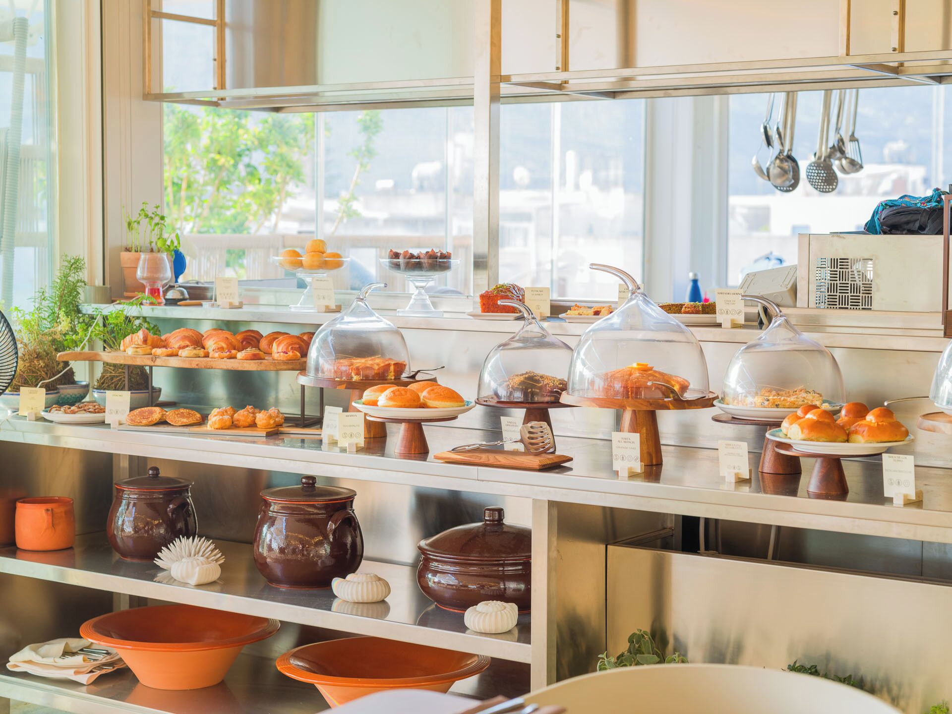 Un buffet della colazione con diversi dolci e pane esposti in vetrine.