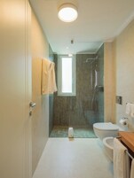 Un baño moderno con ducha, inodoro y lavamanos.