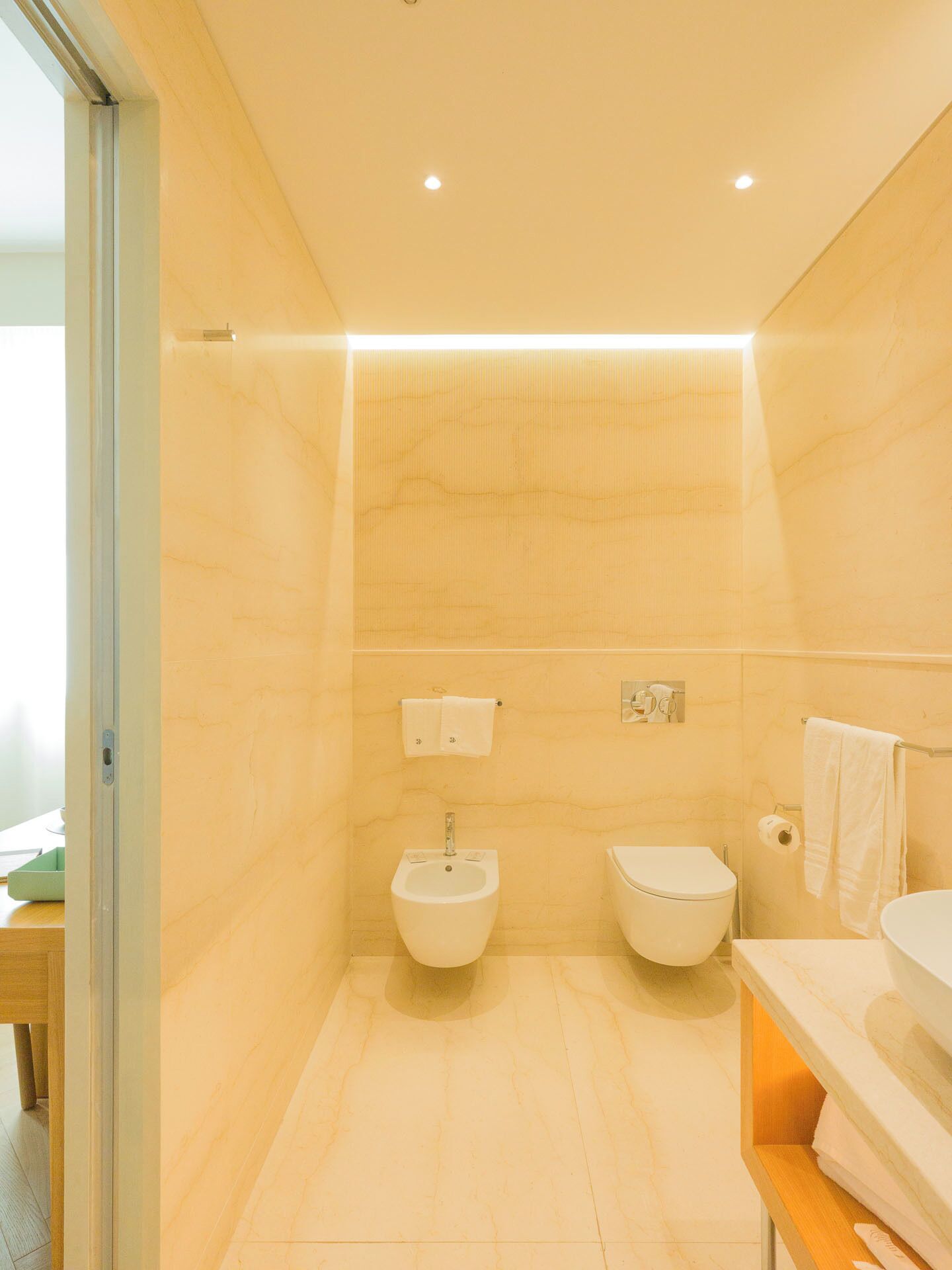 Un bagno moderno con bidet, water e lavandino.