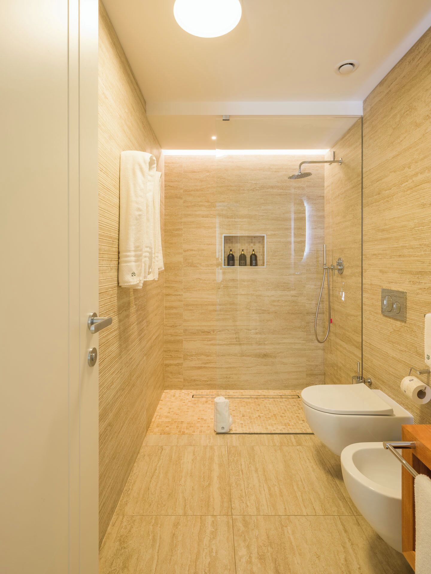 A modern bathroom with a shower, toilet, and sink.