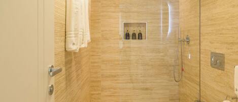 A modern bathroom with a shower, toilet, and sink.