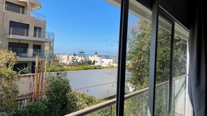 Une vue depuis un balcon donnant sur un quartier résidentiel, avec des bâtiments modernes, un ciel dégagé et quelques espaces verts.