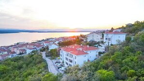 A coastal residential area with buildings, a road, and a body of water. - Apartment Bella (Crikvenica)