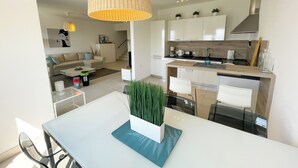 A modern kitchen with white cabinets, a wooden countertop, and a stainless steel range hood. - Apartment Bella (Crikvenica)