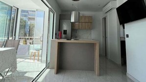 A modern kitchen with a built-in stove, a microwave, and a hanging pot rack. - Lovely studio apartment next to the beach AV-63 (ROSES)