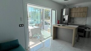 A modern kitchen with a built-in stove, a sink, and wooden cabinets. - Lovely studio apartment next to the beach AV-63 (ROSES)