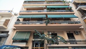 A multi-story building with balconies, air conditioning units, and a tree in the foreground. - Modern Studio, Walking distance to Kolonaki & The Ilisian (Athens)