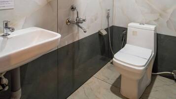 Un baño con un lavamanos blanco, un inodoro y una ducha.