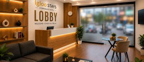 A modern lobby with a reception desk, seating area, and a large window offering a view of the city.