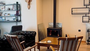 A modern living room with a fireplace, wooden flooring, and a ceiling with exposed beams and lighting. - KAF MOUNT ERCİYES (Hacilar)