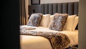 A bed with a fur throw, a headboard with vertical panels, and a lamp on the nightstand. - KAF MOUNT ERCİYES (Hacilar)