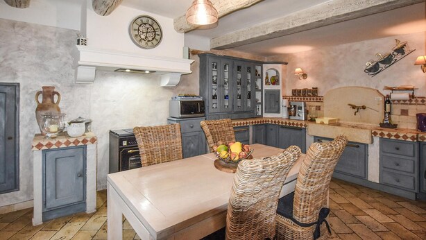 A kitchen with a dining table, wicker chairs, and a fruit bowl. - Luxurious home in Vedène with WiFi (Vedène)