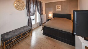 A bedroom with a bed, a bench, a television, and a radiator. - Luxurious home in Vedène with WiFi (Vedène)