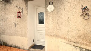 A white door with a glass panel, a small step leading up to it, and a doormat on the ground. - Luxurious home in Vedène with WiFi (Vedène)