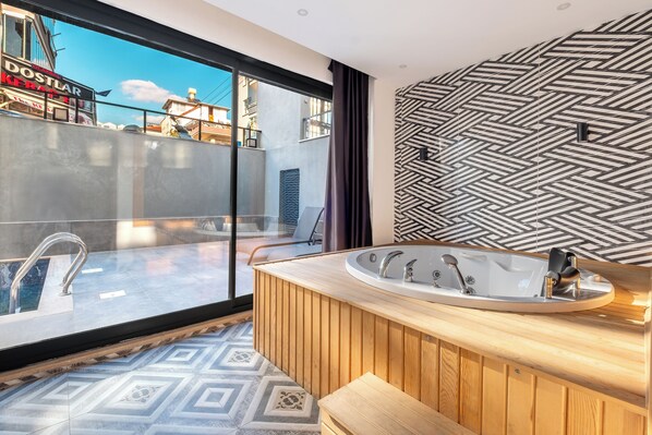 A modern bathroom with a freestanding bathtub, a glass shower enclosure, and a patterned floor.