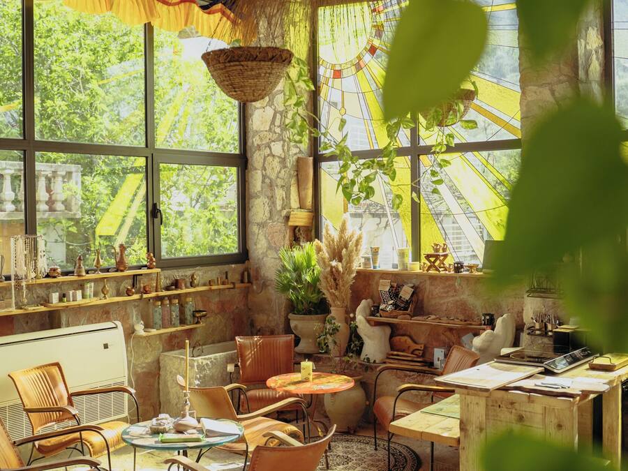 A rustic interior with a large window, wooden furniture, and a hanging basket.