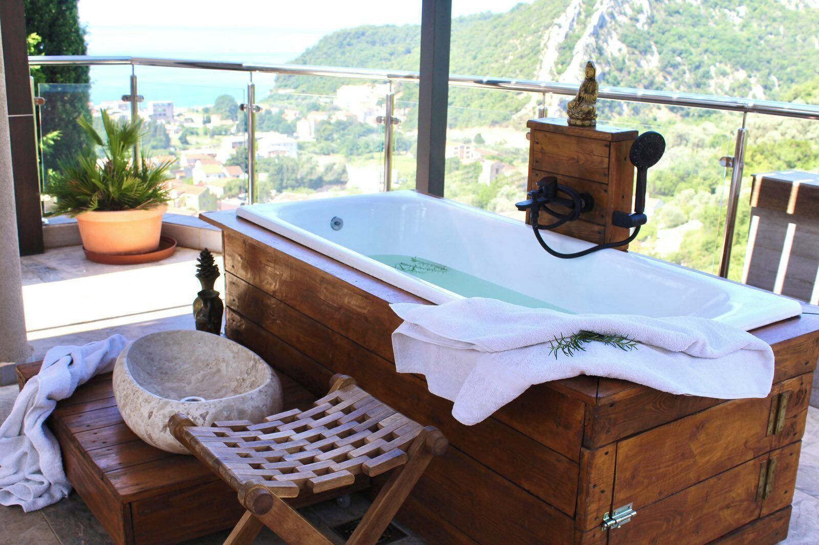 Una bañera de madera con vistas a un paisaje montañoso.