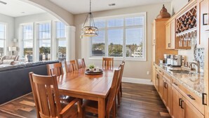 A spacious kitchen with a dining area, large windows, and wooden cabinetry. - Penthouse Paradise at Delton Grand (Wisconsin Dells)