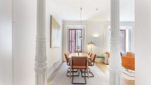 Un comedor con una mesa y sillas de madera, un sofá y una lámpara.