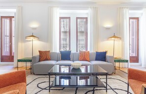Ein modernes Wohnzimmer mit einer Couch, einem Couchtisch und zwei Stehlampen.