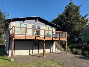 A two-story building with a balcony, a garage, and a sign indicating it's a church. - Welcome to Heron's Hearth (Cape Meares)
