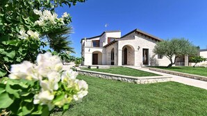 A stone building with arched doorways and a well-maintained lawn. - Stunning home in Noto with house a panoramic view (Noto)