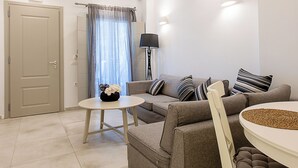 A modern living room with a sofa, a round coffee table, and a lamp. - Santorini Garden Homes (Santorini)