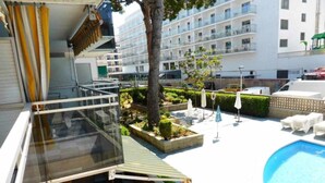 Ein Hotelinnenhof mit Swimmingpool, Sitzgelegenheiten im Freien und Blick auf die umliegenden Gebäude.