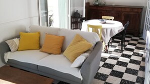 A living room with a grey sofa, wooden coffee table, and a checkered floor.