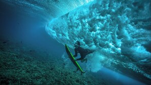 A diver underwater with a surfboard, surrounded by a large wave. - Enchanting bed & breakfast with WiFi & AC in vibrant Thulusdhoo Coke Surf break (Thulusdhoo)