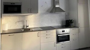 A modern kitchen with white cabinetry, stainless steel appliances, and a central island. - Stay In Karesuando (Karesuando)