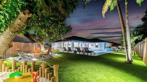 A modern house with a well-maintained lawn, outdoor seating area, and a pool. - Grand Lux Villa /Heated Pool/Spa/Game fun/Nr Beach (Lantana)