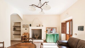 Una sala de estar con chimenea, una mesa de comedor y un sofá de cuero.