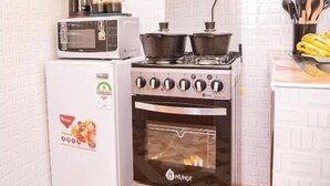 A compact kitchen with a built-in oven, a microwave, and a stove. - Havana Cottages-Telaviv (Nakuru)