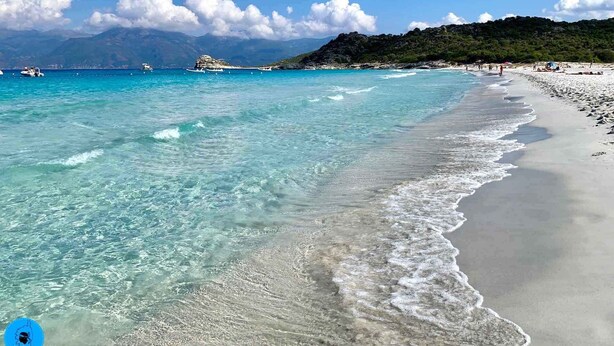 A beach with clear turquoise water, a sandy shore, and a mountainous backdrop. - CASA LECCIA, Luxurious villa with swimming pool 5' drive from ST FLORENT (Patrimonio)