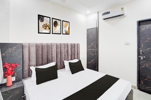 Et moderne hotelværelse med en stor seng, en marmorbeslag og en vægmonteret aircondition.