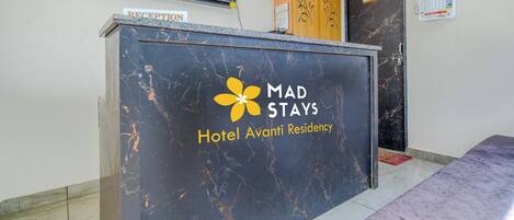 A reception desk at Hotel Avanti Residency with a sign indicating the reception area.