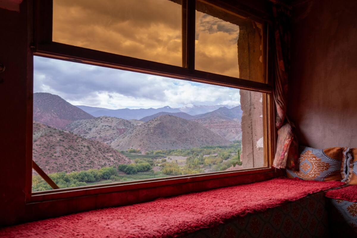 A room with a large window overlooking a mountainous landscape.