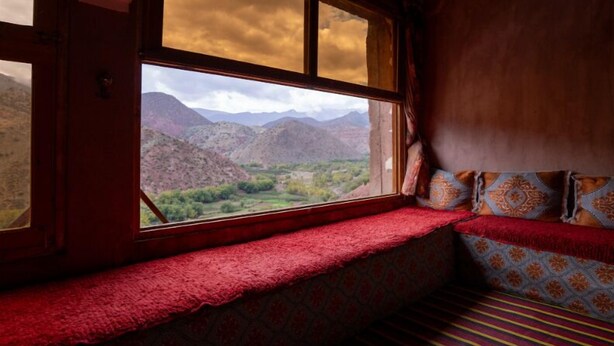 A room with a large window offering a view of mountains and a valley. - Gite Azoul (Beni Mellal)